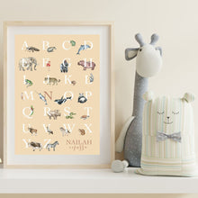 Load image into Gallery viewer, Personalised Kids' Animal Alphabet Poster in a neutral, sand colour. Featuring watercolour animals corresponding to the alphabet. Personalised with a child's full name. Framed and placed on a shelf in a child's room.